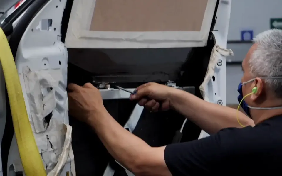 Técnico instalando blindaje en la puerta de un vehículo